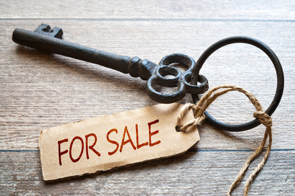 Old key with paper label - For sale text - on wooden background. Real Estate Concept.  - 写真・画像
