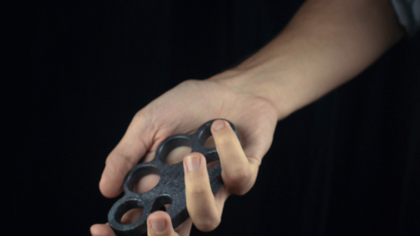 Placing knuckle-duster on the hand - Felvétel, videó