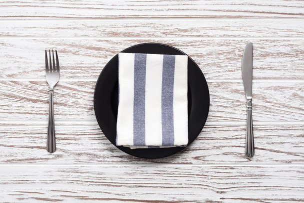 empty plate napkin fork knife silverware white wooden table back - Foto, Bild