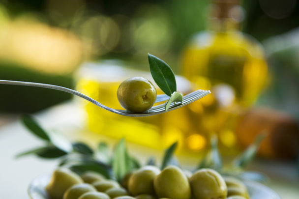 olive on fork with green background - Foto, Imagen
