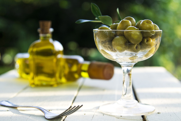 olives and bottles of oil with slice of bread on vintage woo - Foto, afbeelding