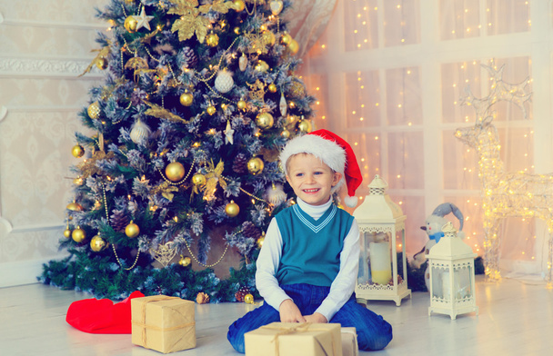 little boy with christmas presents in decorated living room - Foto, Imagem