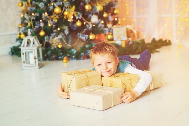 pieni poika joululahjat koristeltu olohuone
 - Valokuva, kuva