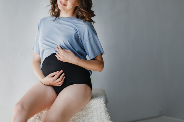 Felismerhetetlen terhes nő ül egy fotó stúdió - Fotó, kép