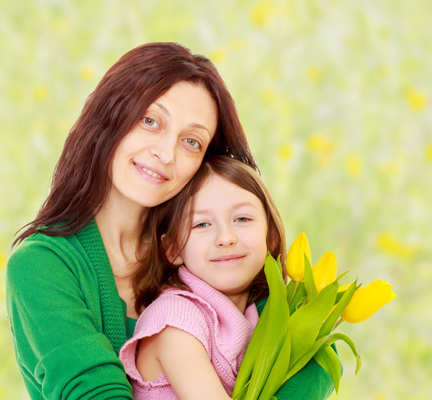 Portrait of mother and daughter with a bouquet  tulips. - Photo, Image