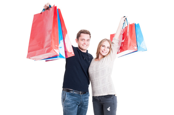 Happy couple holding up bunch of shopping bags - Φωτογραφία, εικόνα
