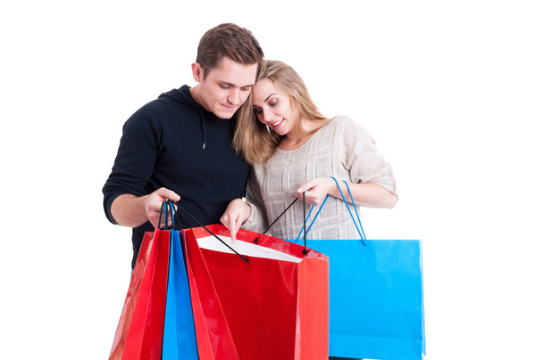 Casal olhando em sacos de compras e sendo conteúdo
 - Foto, Imagem