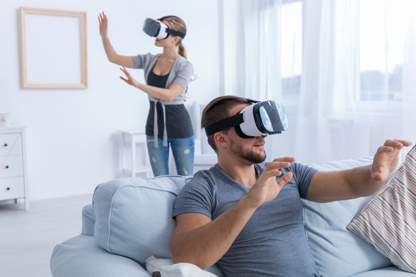 Couple relaxing at home using VR glasses - Фото, зображення