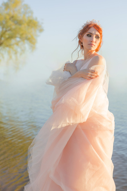 Portrait of beautiful bride standing by the beach at sunset - Foto, immagini