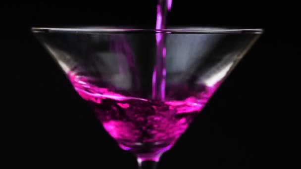 Verter cóctel rojo en vaso de martini sobre fondo negro
 - Imágenes, Vídeo