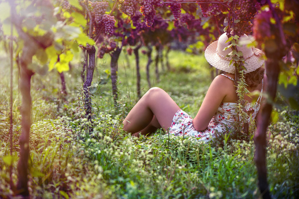 Beautiful female in the hat in the vineyard  - Photo, image