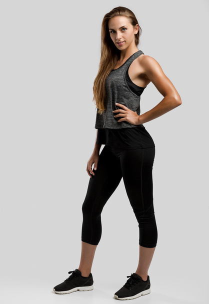 fitness woman standing with hand on belt - Foto, afbeelding