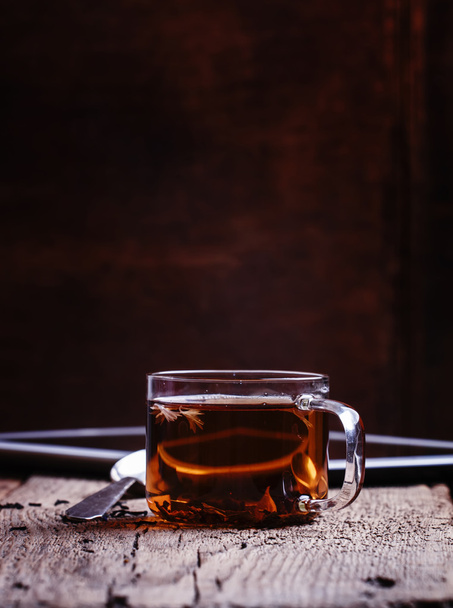 Cup of black hot tea with spoon and digital tablet   - Fotografie, Obrázek