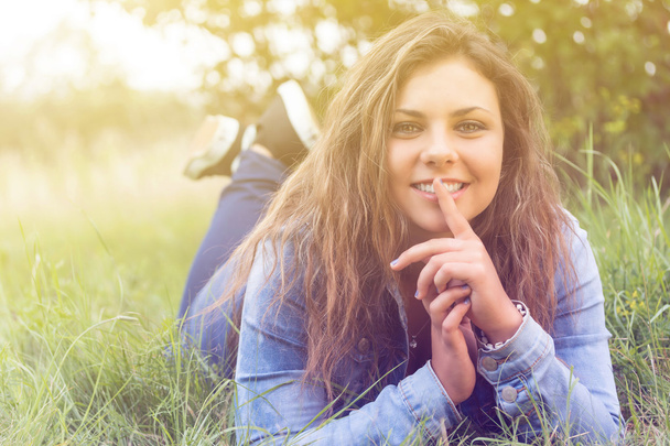 Smiling teenage girl lying outdoors  - 写真・画像