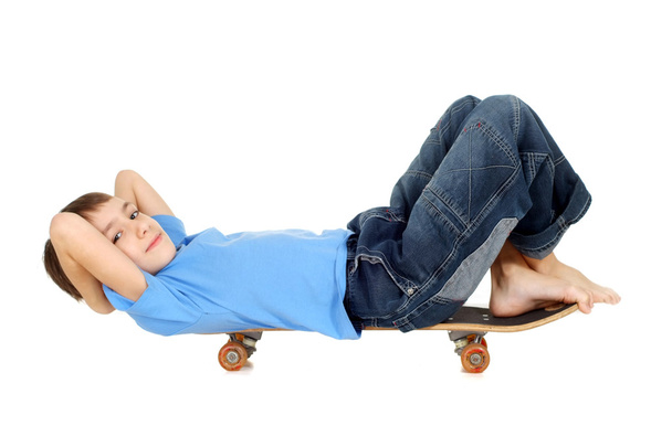 Boy lying on a skateboard - 写真・画像