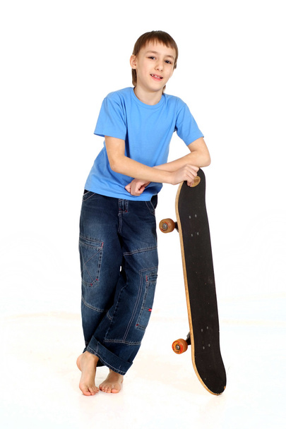 Boy leaning on skateboard - Photo, image