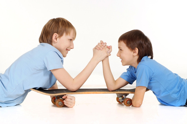 Two boys are fighting on a skateboard - Zdjęcie, obraz