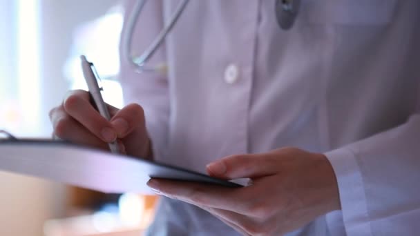doctor holding pen and medical chart - Video, Çekim