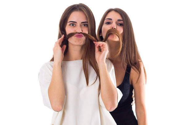 Duas jovens fazendo bigode de seu cabelo
 - Foto, Imagem