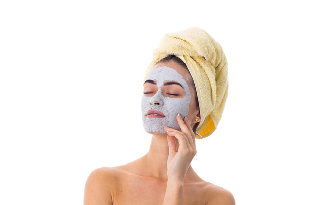 Женщина с полотенцем на голове и косметической маской на лице
 - Фото, изображение