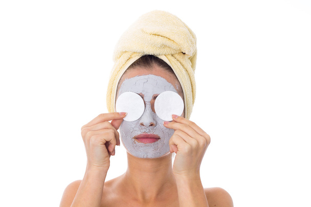 Γυναίκα με πετσέτα στο κεφάλι και καλλυντικά μάσκα στο πρόσωπό της - Φωτογραφία, εικόνα