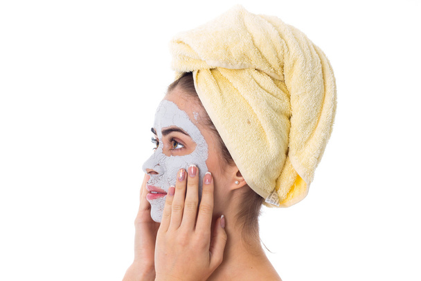彼女の頭と彼女の顔に化粧品のマスクにタオルを持つ女性 - 写真・画像