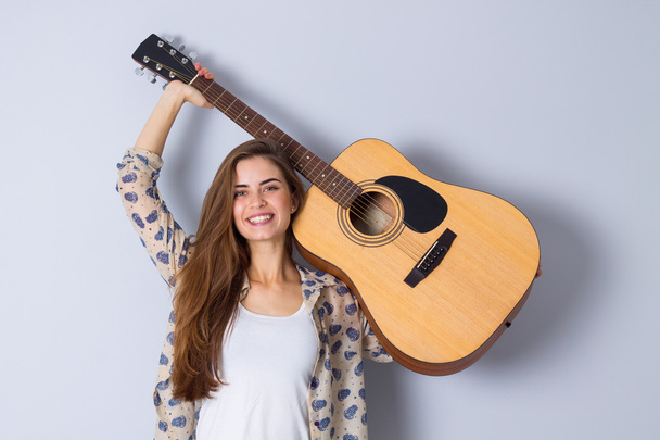 Giovane donna che tiene una chitarra
 - Foto, immagini