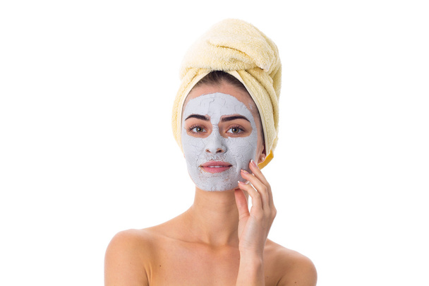 Kobieta z ręcznikiem na jej głowie i kosmetycznych maska na twarz - Zdjęcie, obraz
