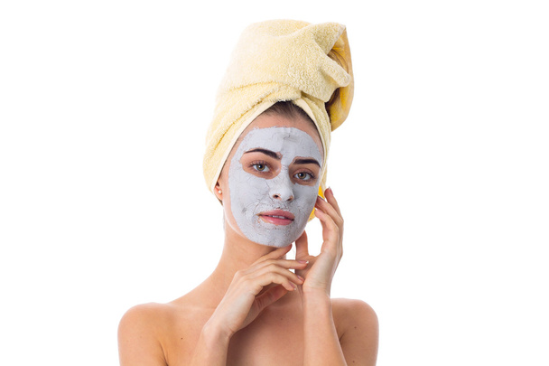 Kobieta z ręcznikiem na jej głowie i kosmetycznych maska na twarz - Zdjęcie, obraz