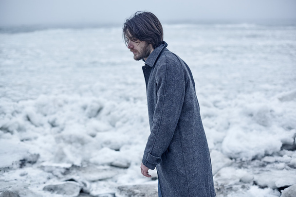 Muž v šedém plášti procházky u moře - Fotografie, Obrázek