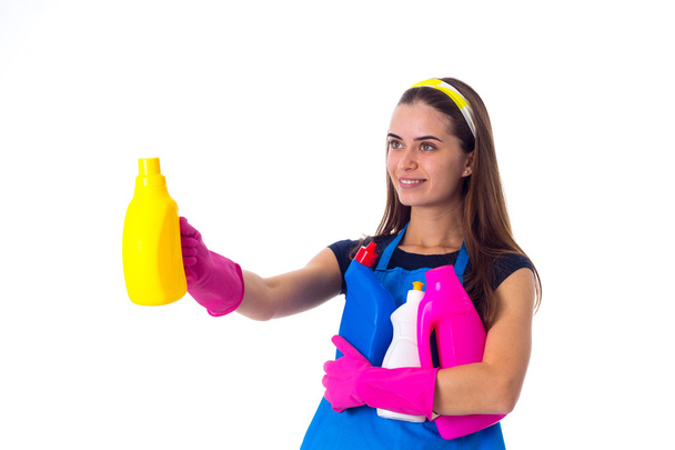 Женщина в фартуке держит моющие средства
 - Фото, изображение