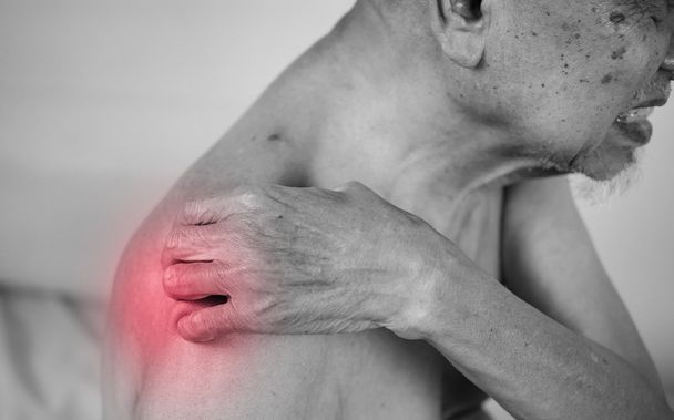 senior man holding he shoulder on pain area. red effect - Photo, Image
