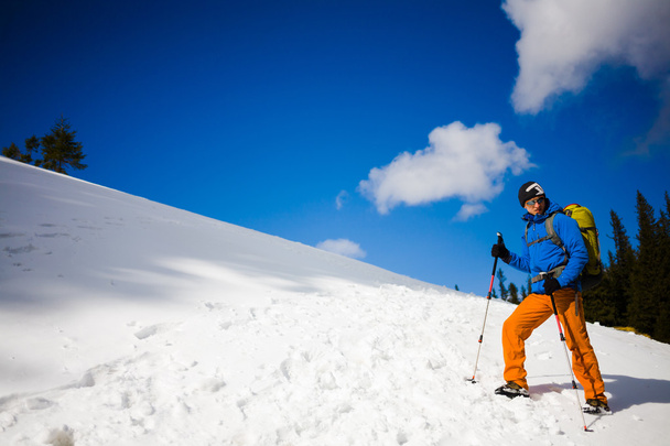 Bergsteiger wandert auf schneebedecktem Hang. - Foto, Bild