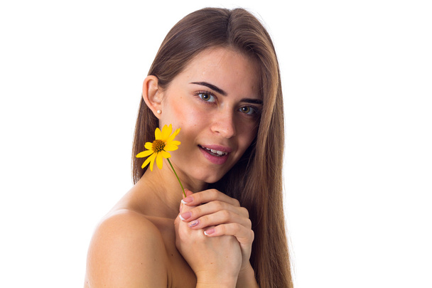 Nuori nainen pitkät hiukset tilalla keltainen kukka
 - Valokuva, kuva