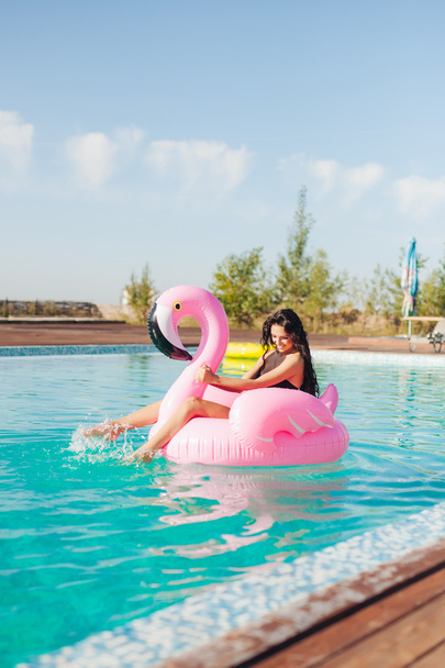 girl sits on inflatable mattress flamingo - Φωτογραφία, εικόνα