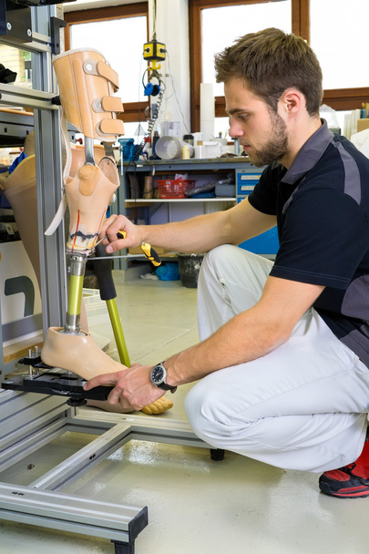 Homem trabalhando na perna protética
  - Foto, Imagem