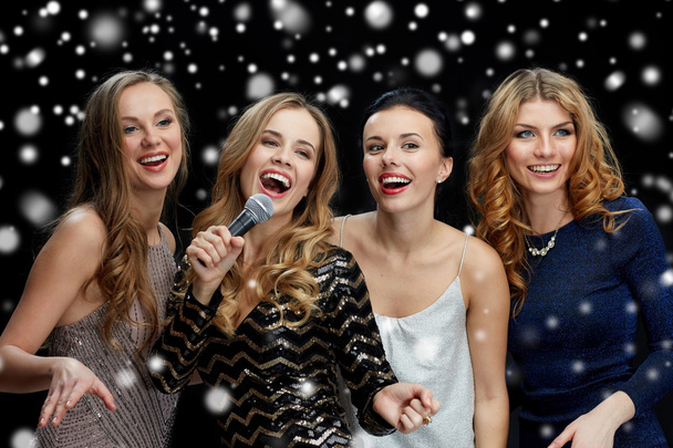 happy young women with microphone singing karaoke - Foto, Imagen