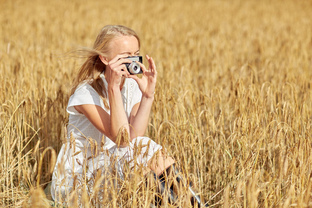 woman taking picture with camera in cereal field - Foto, Imagen