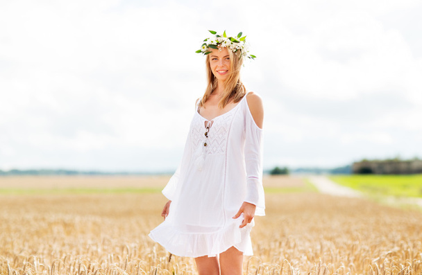 happy young woman in flower wreath on cereal field - Photo, image