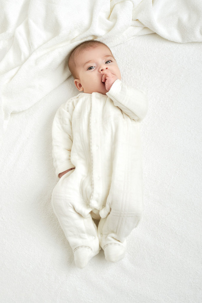 baba portait hazugság fehér törülközőt az ágyban, sárga tónusú - Fotó, kép