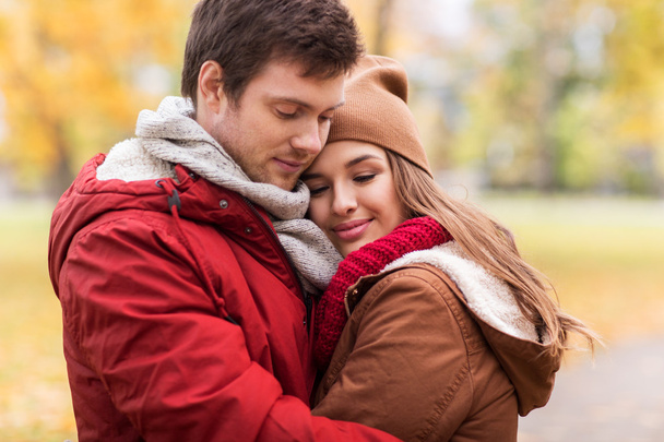 close up of happy couple hugging in autumn park - Foto, Imagen