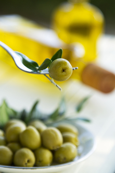 olive on fork with green background - Foto, Imagen