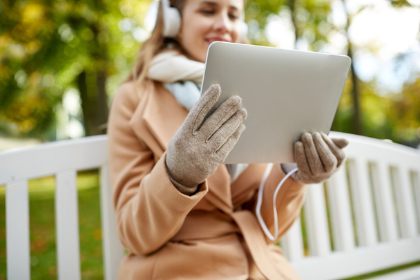 mujer con tablet PC y auriculares en el parque de otoño
 - Foto, Imagen