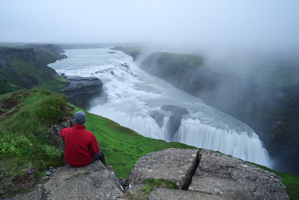 Tourist looks at the big waterfall in Iceland - Photo, Image
