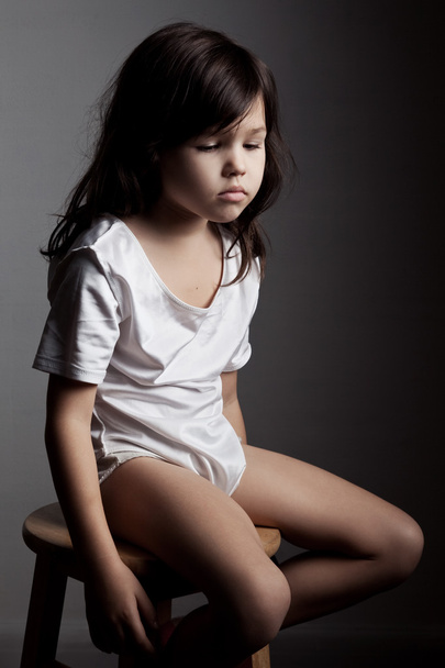 Menina triste sentada na cadeira
  - Foto, Imagem