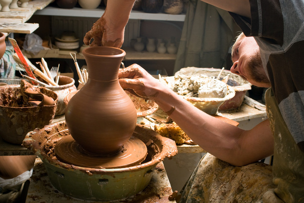 Руки гончаря, створюючи глиняну банку на колі
 - Фото, зображення