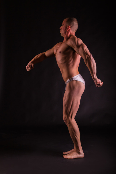 very muscular handsome athletic man on black background - 写真・画像