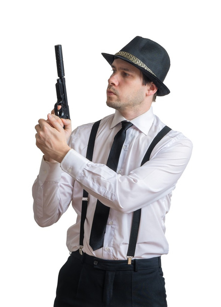 Young mafia man or racketeer holds gun with silencer in hands. Isolated on white background. - Foto, Imagen