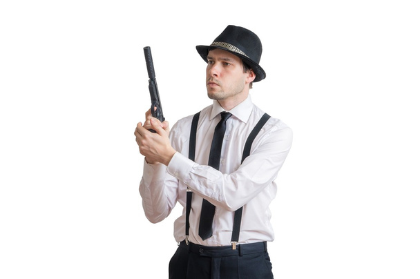 Young detective holds gun with silencer in hands. Isolated on white background. - 写真・画像