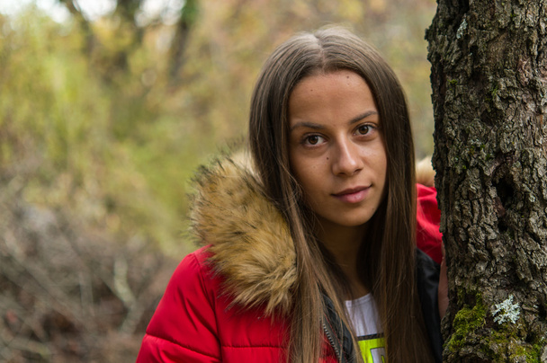 Fiatal nő egyedül a piros kabátot visel az erdő - Fotó, kép